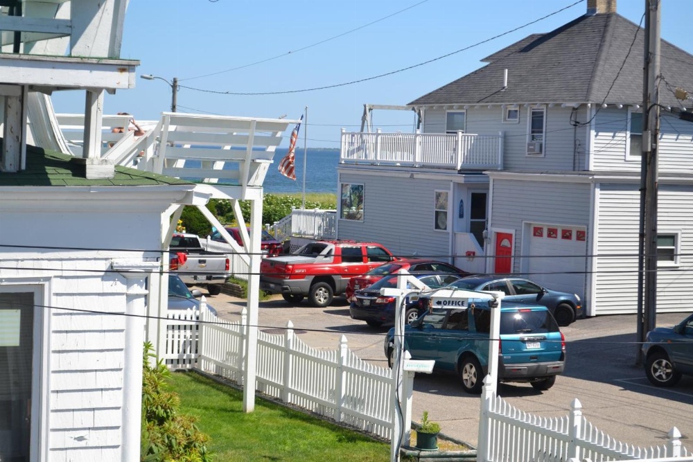 A white building with a parking lot and ocean view