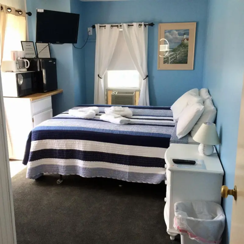 A standard hotel room with a bed, TV, fridge, microwave, and coffee maker.