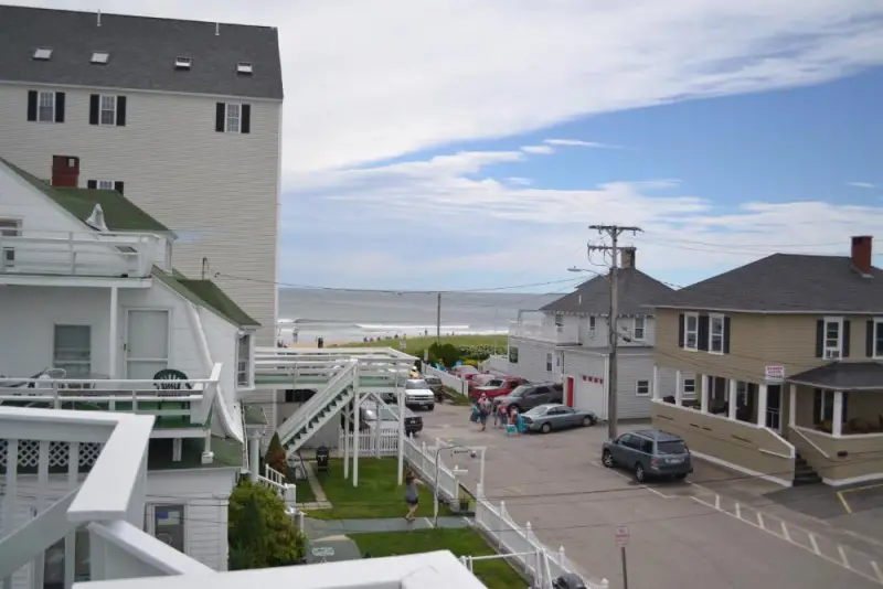 A wide-angle view of the hotel's exterior, showing its parking lot and proximity to the beach.