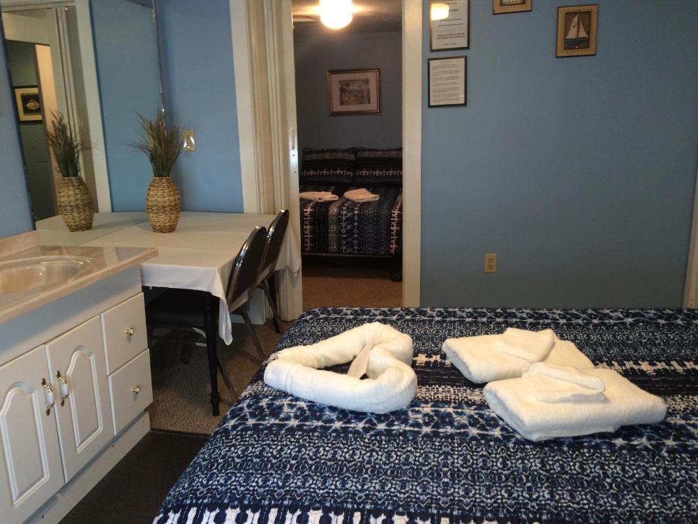 A hotel room with a bed, sink, and table